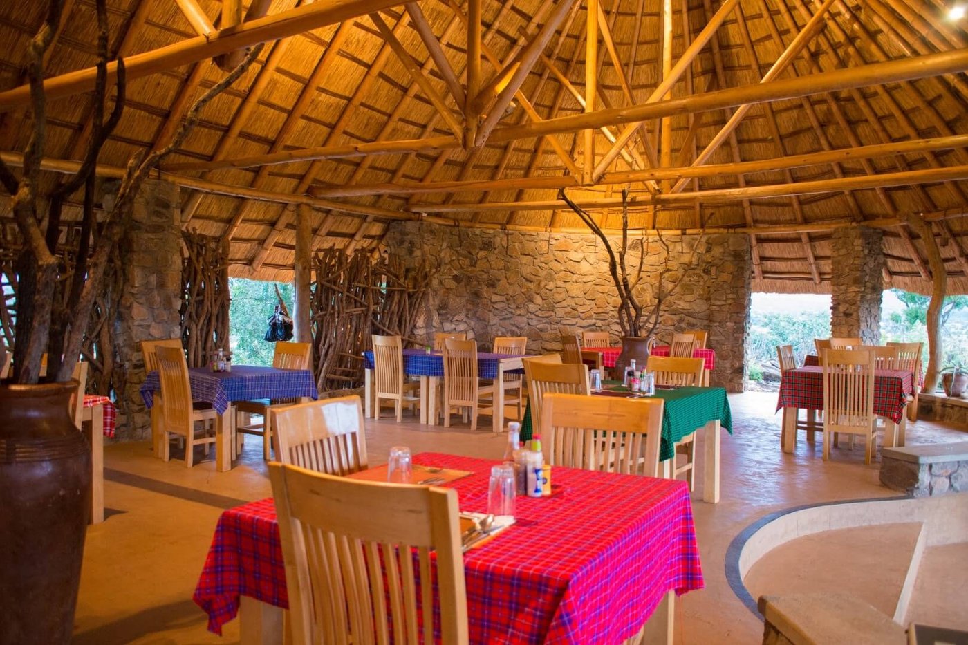Strohdachgedeckte Speisehalle mit bunten Tüchern in der Kidepo Savannah Lodge