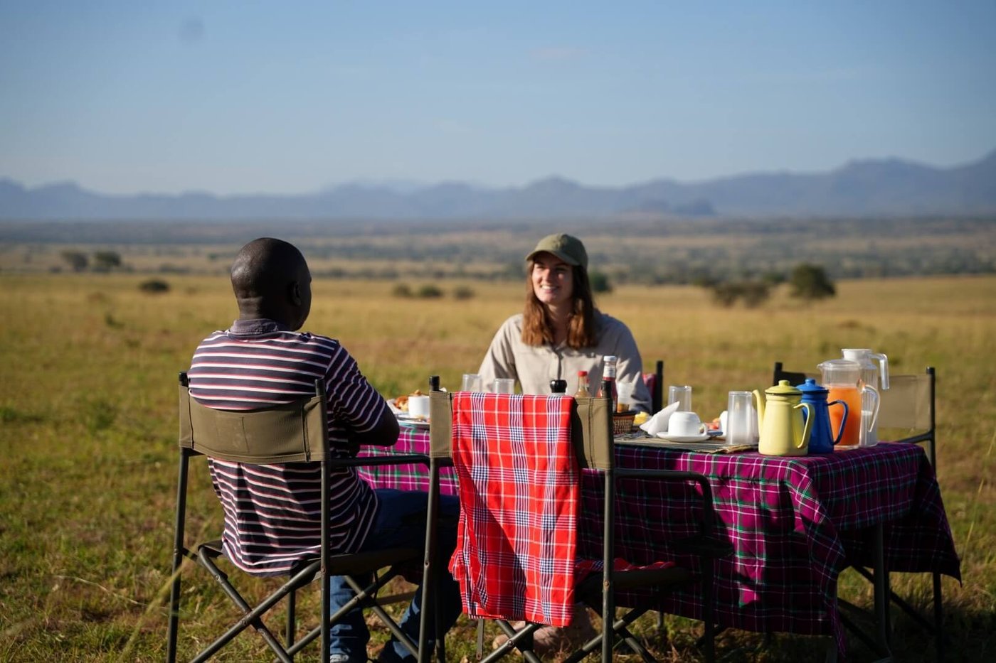 Gäste teilen sich ein Bush-Frühstück mit Blick auf die Ebenen in der Kidepo Savannah Lodge
