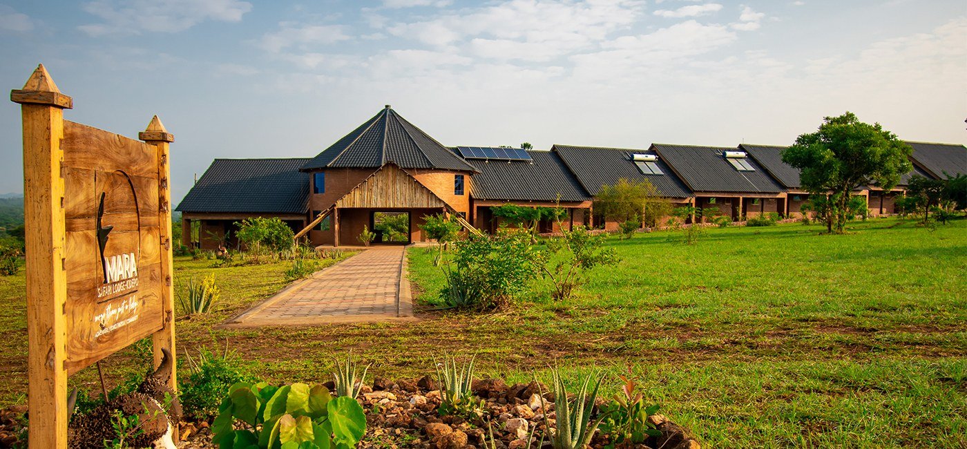 L'enseigne d'entrée et la ligne de toit chaumé de Mara Safari Lodge Kidepo