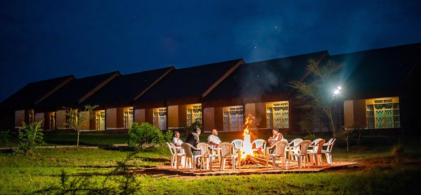 Les clients se rassemblent autour du feu de camp du soir à Mara Safari Lodge Kidepo